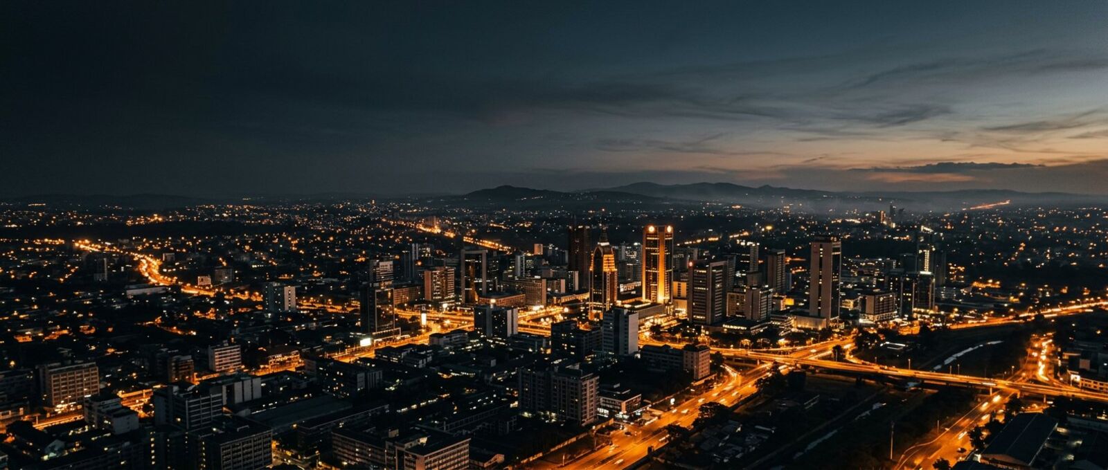 Nairobi at dusk, seen from above, with warm street lights across the city.